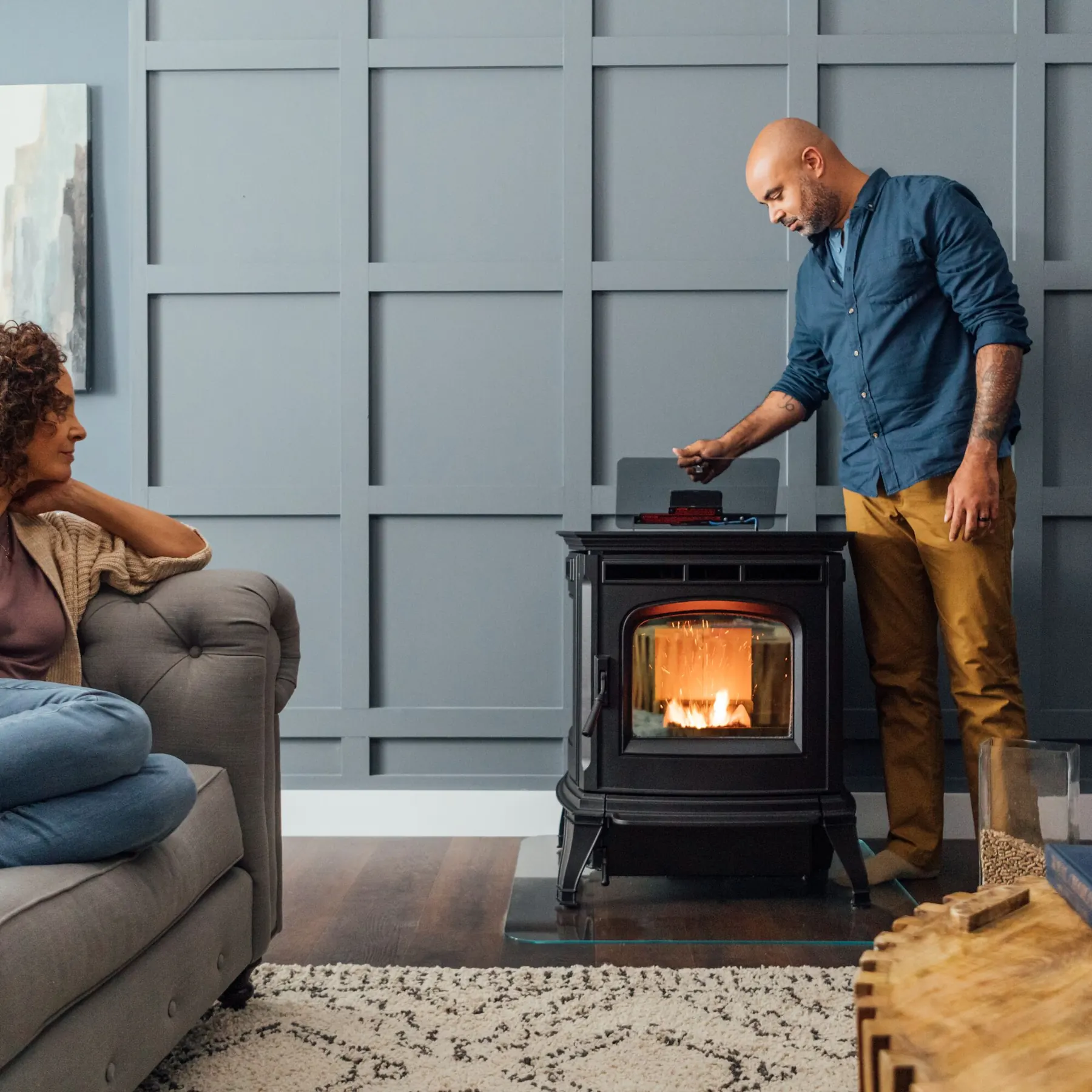 A homeowner beside a burning Harman Absolute63 pellet stove