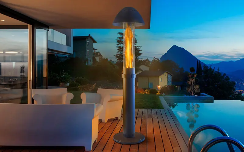 A Primato pellet patio heater lit on a terrace at dusk