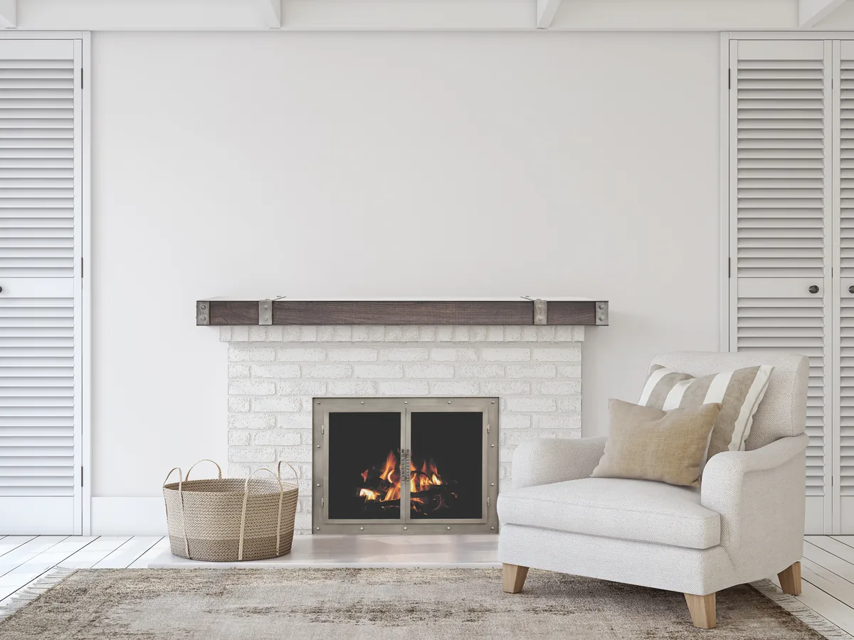A Stoll Transitional glass door on a whitewashed brick fireplace under a wood mantel, the fire showing through the glass